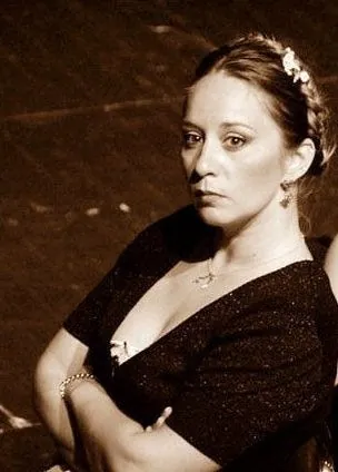 Sepia portrait of Ferzan in a dark dress with flowers in her hair